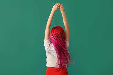 Beautiful woman with bright hair on green background, back view