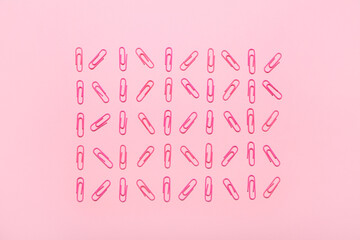 Pink paper clips on color background