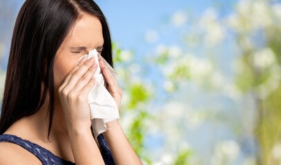 Woman allergic suffering from seasonal allergy at spring garden. Spring allergy concept