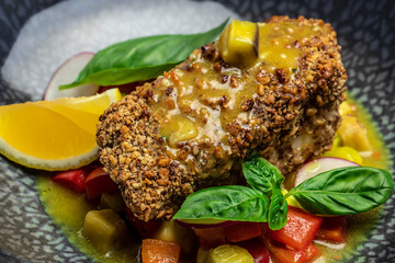 Close up fish fillet breaded in nuts with pepper sauce and vegetables, Healthy fats, clean eating...