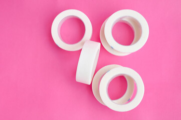 White tap for eyelash extensions on pink background