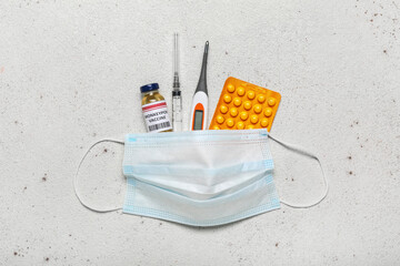Monkeypox vaccine, syringe, thermometer, pills and medical mask on light background