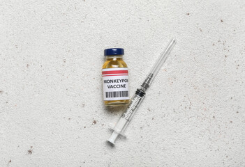 Monkeypox vaccine and syringe on light background