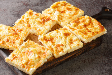 Alevropita crispy feta pie is a specialty of Epirus close-up on a wooden board on the table. Horizontal
