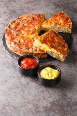 Savory Southern Style Cheeseburger Pie with ground beef cheddar cheese and onion close-up on a slate board on the table. vertical