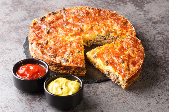 Delicious Popular Meat Cheeseburger Pie Served With Sauces Close-up On A Slate Board On The Table. Horizontal