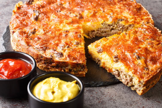 Beef Cheeseburger Pie Served With Sauces Close-up On A Slate Board On The Table. Horizontal