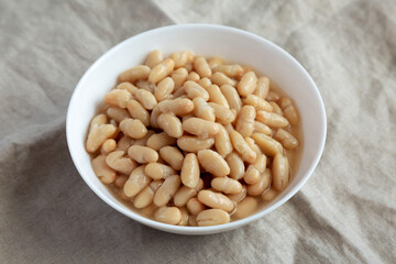 Organic White Cannellini Beans in a White Bowl, side view.