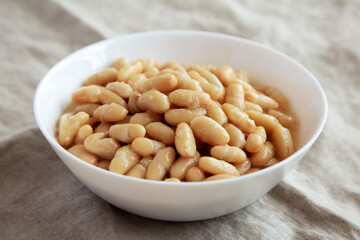 Organic White Cannellini Beans in a White Bowl, side view.