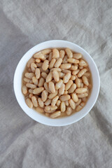 Organic White Cannellini Beans in a White Bowl, top view. Flat lay, overhead, from above.