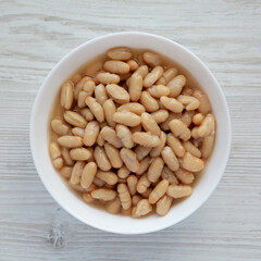 Organic White Cannellini Beans in a White Bowl, top view. Flat lay, overhead, from above.