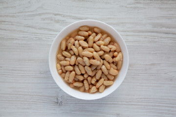 Organic White Cannellini Beans in a White Bowl, top view. Flat lay, overhead, from above.