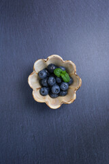 陶器の器に盛られたブルーベリー、スレート