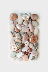 Aesthetic minimal pattern with set of sea pebble stones on white background. Square composition from natural round smooth stone pink grey color. Collection of rocks, summer concept, top view