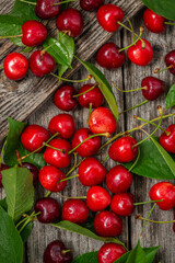 Ripe cherry berries with water drops on an old wooden background. Food texture background, flat lay top view