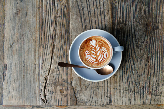 Looking down at a flat white on a wooden table