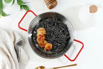 Black Spanish Rice paella with Squid Ink and Fried Shrimp as Topping.