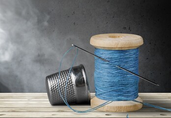 A sewing thread with needle on dark background,