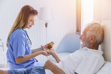 elderly man senior people lay on bed health care giving medicine pills from nurse at homecare