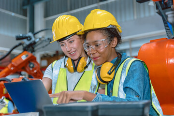 Obraz na płótnie Canvas Women engineer worker working team helping together at work in modern advance machine factory.