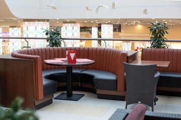 Round table in a restaurant, round chair made of ecological leather, stylish interior in a cafe