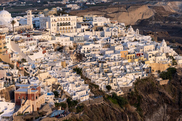 Obraz premium The whitewashed town of Fira in warm rays of sunset on Santorini island, Cyclades, Greece