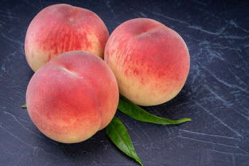 Sweet Peach fruit with leaf on black wooden background, Fresh Sweet Peach on black wooden table.