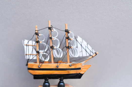 Tiny wooden toy ship on pastel background copy space