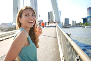 Photo sur Plexiglas Pont Érasme Portrait of lively girl turns around and smile to the camera with modern cityscape on the background, Rotterdam, Netherlands