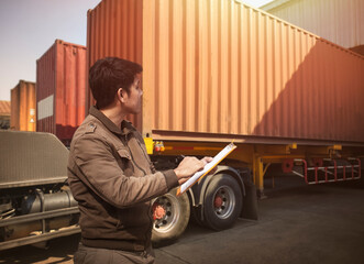 Worker Holds a Clipboard Controlling the Loading of Cargo into Shipping containers. Trucks Parked Loading at Dock Distribution Warehouse. Freight Truck Cargo Transport Logistics.	
