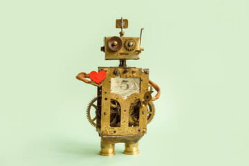 The old robot is holding a heart. Logic and emotions concept.