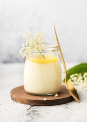 Homemade elder flower dessert panna cotta, mousse or pudding in a portion glass jar with lemon curd...