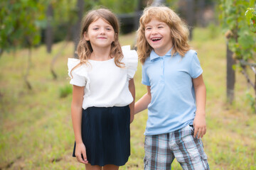Two children walking outdoors. Portrait of adorable brother and sister smile and laugh together. Happy lifestyle kids.