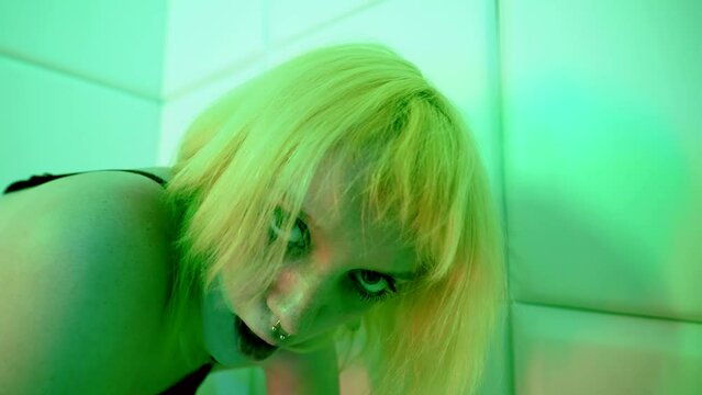 playful young woman is seducing, looking at camera, licking lips, prostitute in bordello