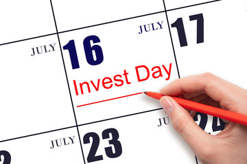 Hand drawing red line and writing the text Invest Day on calendar date July 16. Business and...