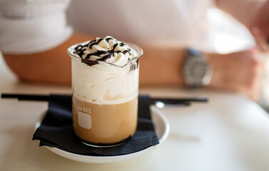 Delicious coffee with whipped cream in a glass