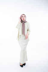Fototapeta premium Beautiful female model in poses wearing traditional apparel and hijab, an urban lifestyle look for Muslim women isolated on white background. Beauty and hijab fashion concept. Full length
