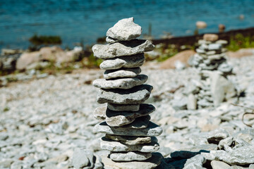 Stone figures on the beach of the Sorve Peninsula in the Ojessaare Nature Reserve. Estonia, Saaremaa. Horizon over sea in summer time. Pebble beach.