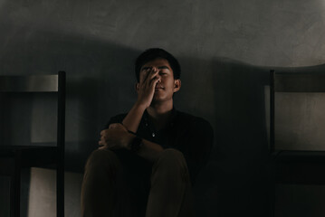 Sad and depressed young male sitting on the floor in the room, sad mood,feel tired, lonely and...
