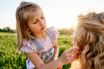 Little girl spending time with mom at the meadow