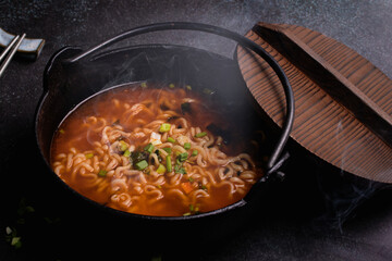 Spicy Korean Instant Noodles with Wakame Seaweed in a Black Iron Pot, Korean Food Traditional Style