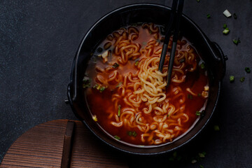 Spicy Korean Instant Noodles with Wakame Seaweed in a Black Iron Pot, Korean Food Traditional Style