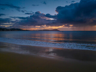Obraz premium Aerial sunrise at the seaside with rain clouds
