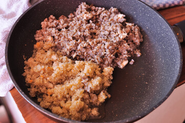 Boiled buckwheat and quinoa on frying pan for breakfast . High quality photo