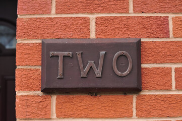 The word two on the red brick wall background . High quality photo