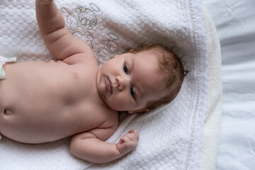 Little month old girl on a white sheet. Filmed in daylight.