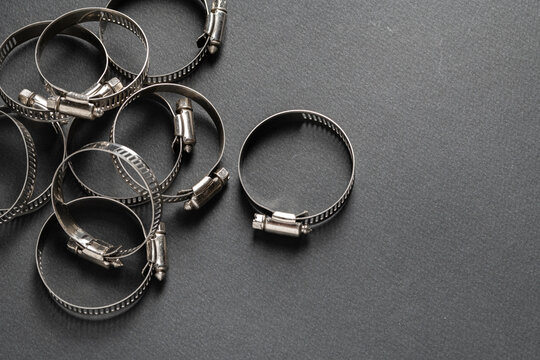 Metal hose clamp on black background. Empty space for text