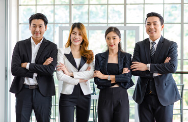 Portrait shot group of Asian happy cheerful millennial professional successful male businessman and female businesswoman in formal suit standing smiling cross hands holding together showing teamwork