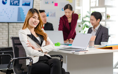 Portrait shot Asian young happy cheerful confident millennial professional successful female businesswoman in formal suit sitting crossed arms smiling while colleagues working in blurred background