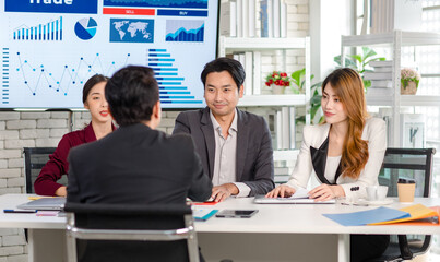 Asian young millennial female businesswoman standing holding showing tablet computer asking consulting with professional successful male businessman manager mentor in formal suit in meeting room